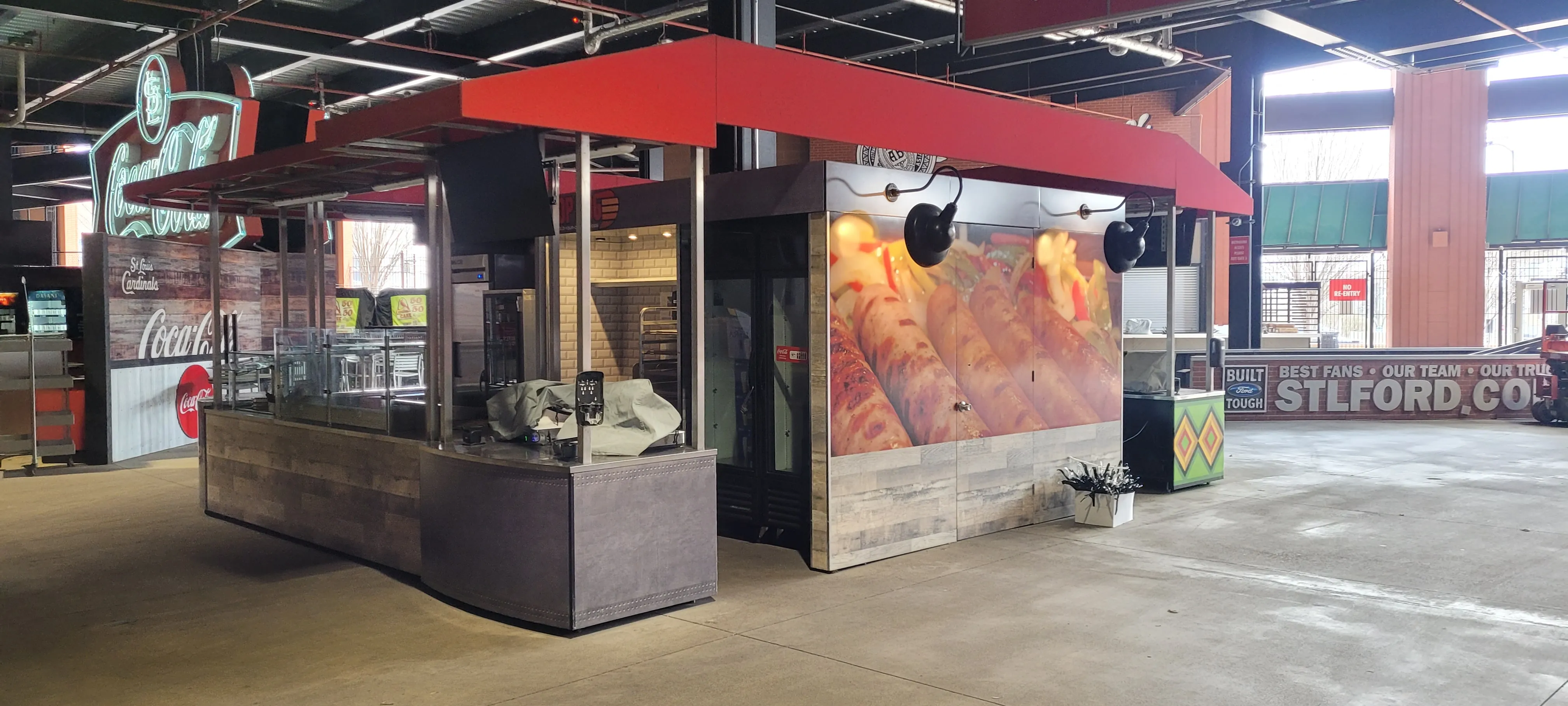 Red-canopy kiosk with a food graphic wall and wood-look panels