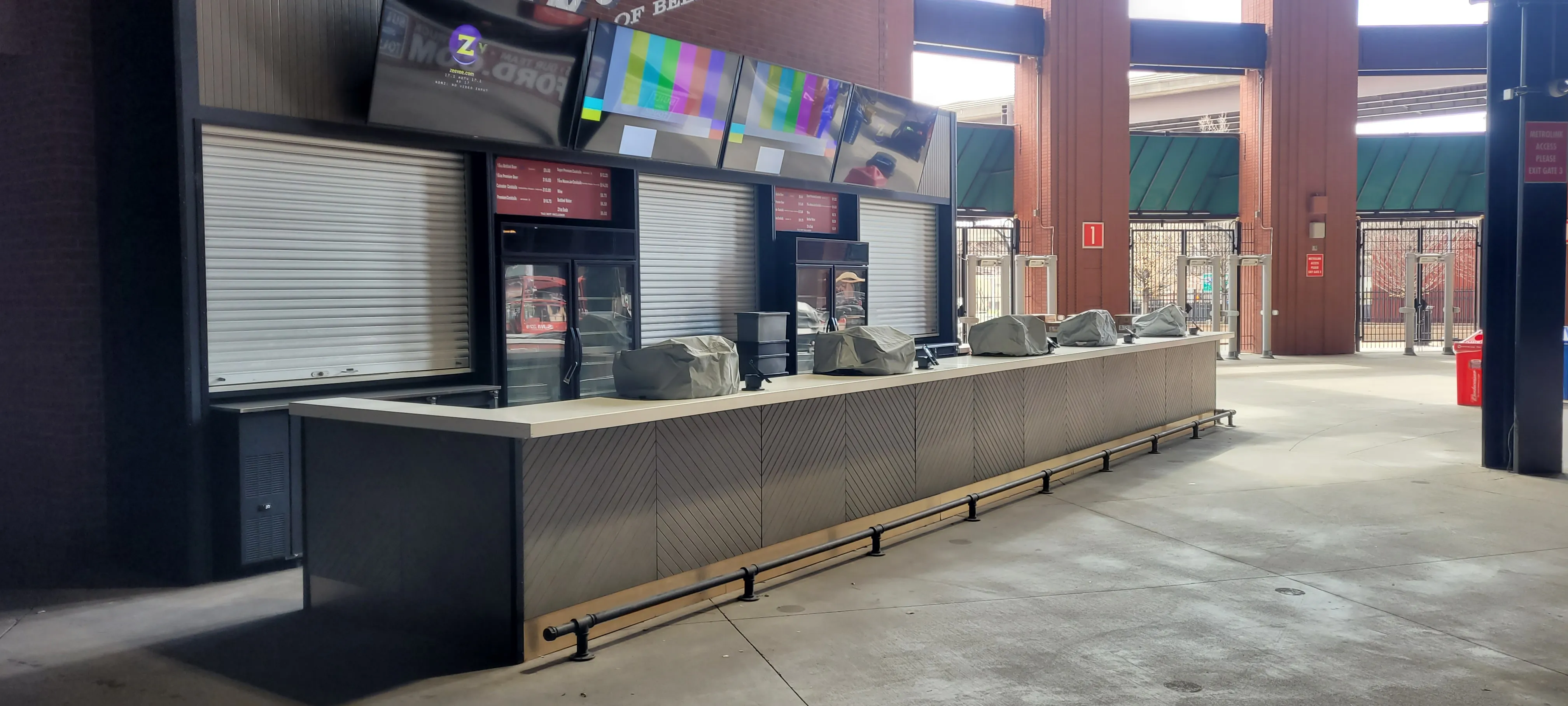 Long concession counter with chevron-patterned panels and roll-down shutters