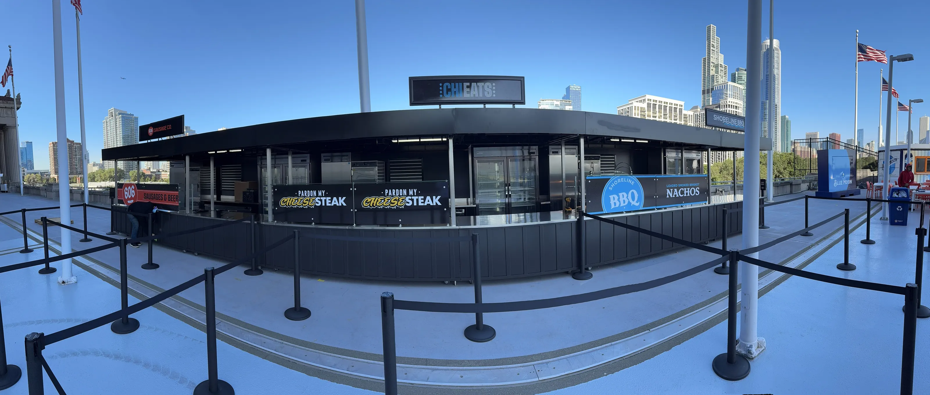 CHI EATS concession kiosk on a stadium concourse, with the Chicago skyline behind it